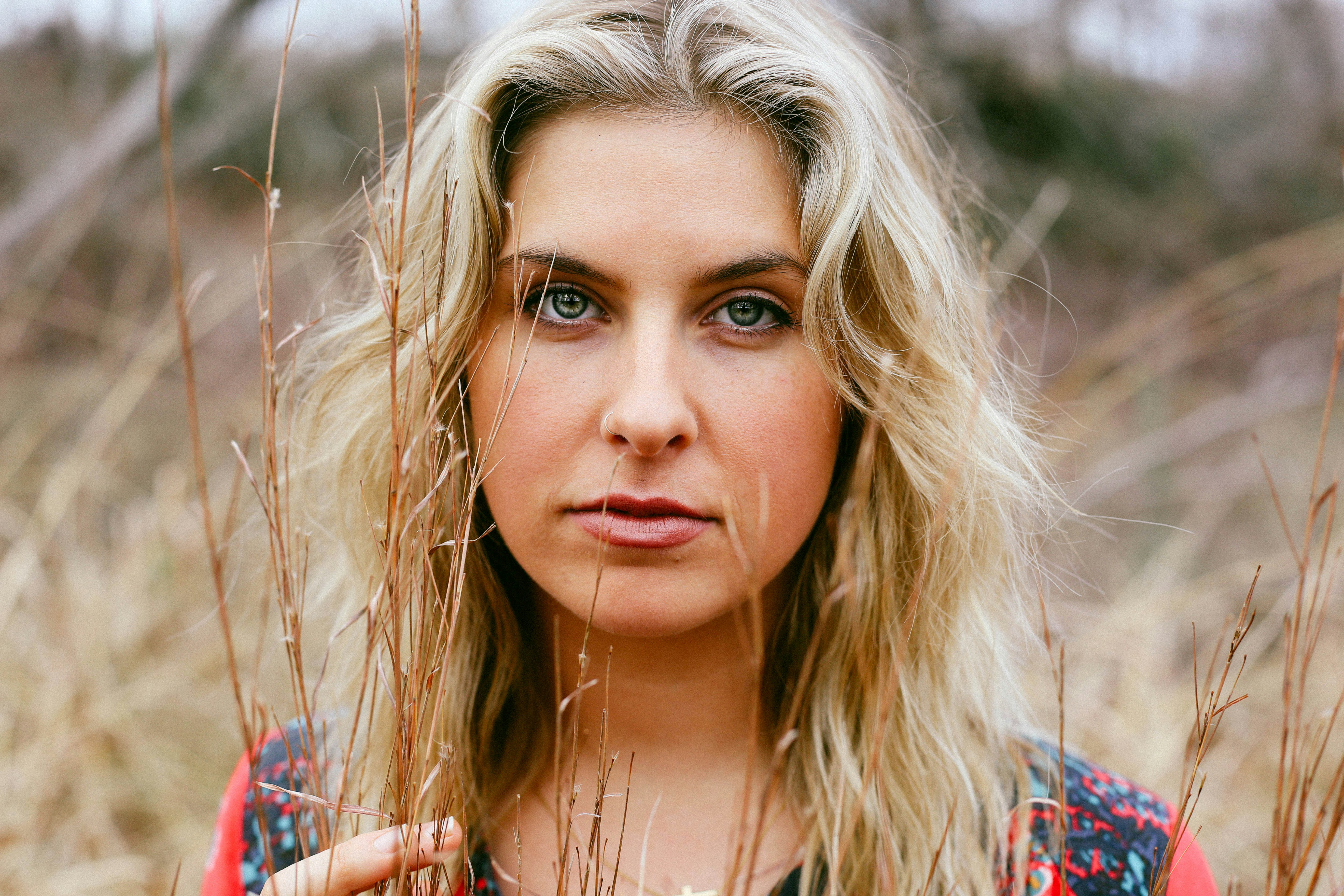 shallow focus photography of woman standing on grass field